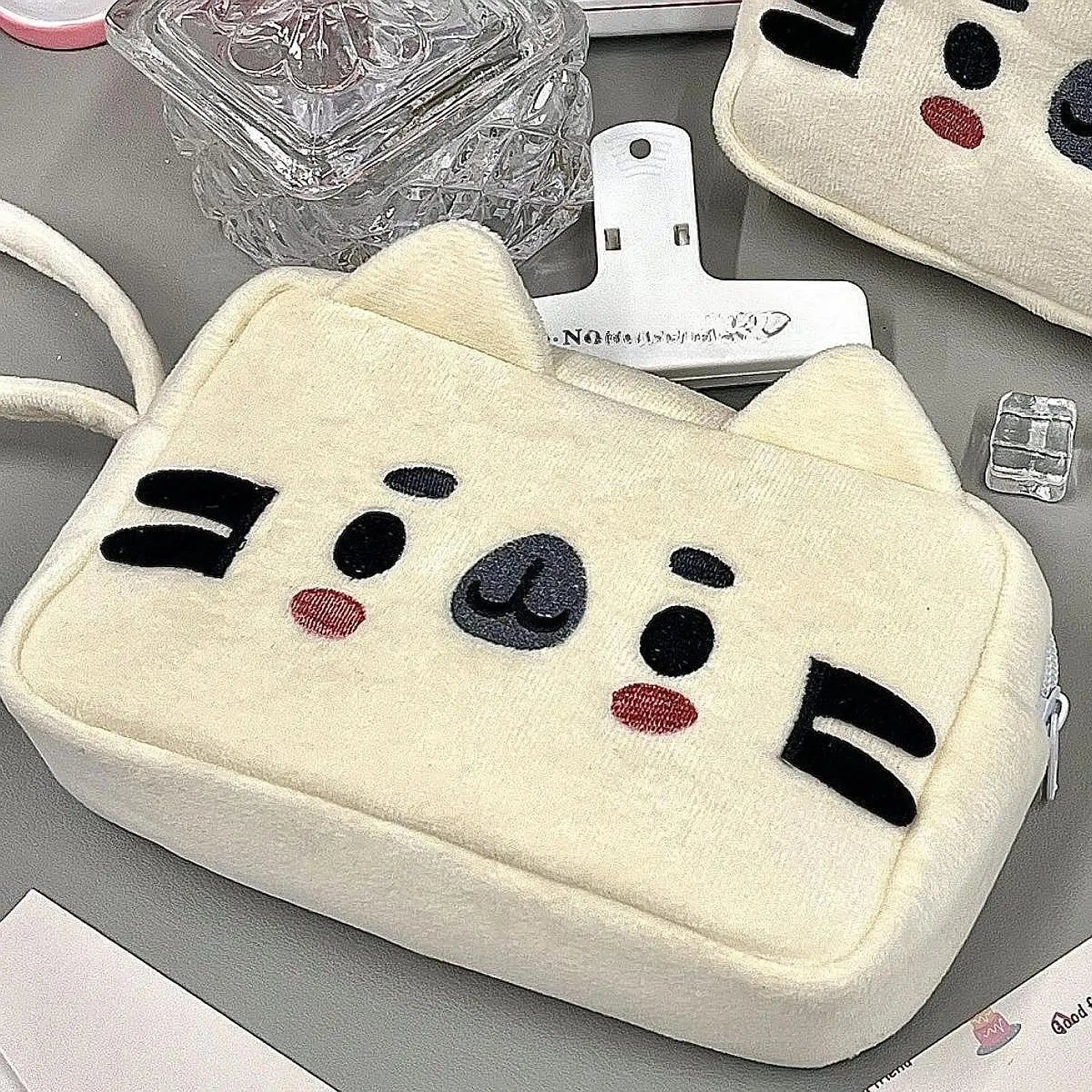 Cute pouch with kawaii cat face design on a gray surface