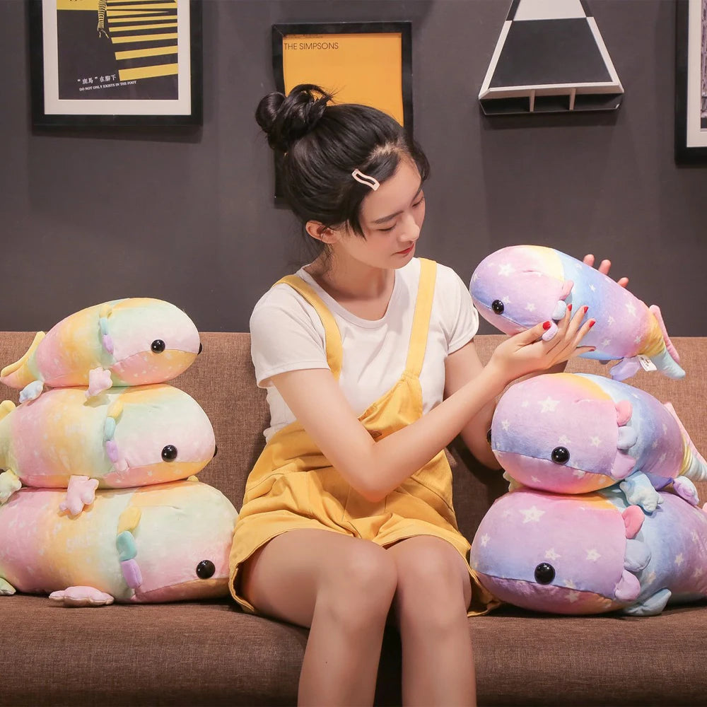 Woman sitting on a couch holding a colorful kawaii plush toy, with more plush toys stacked behind her.