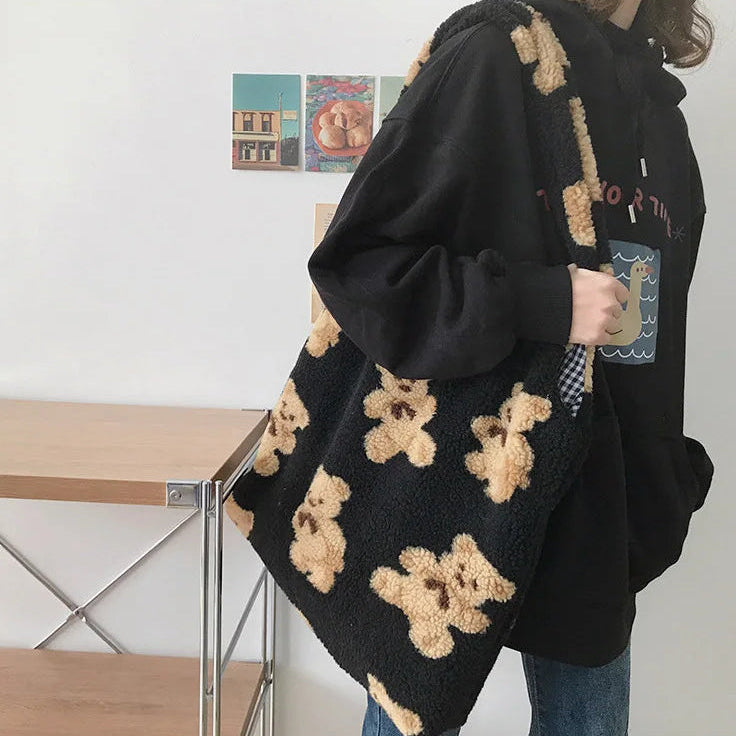 Person wearing a black hoodie with kawaii teddy bear patterns in a casual setting.