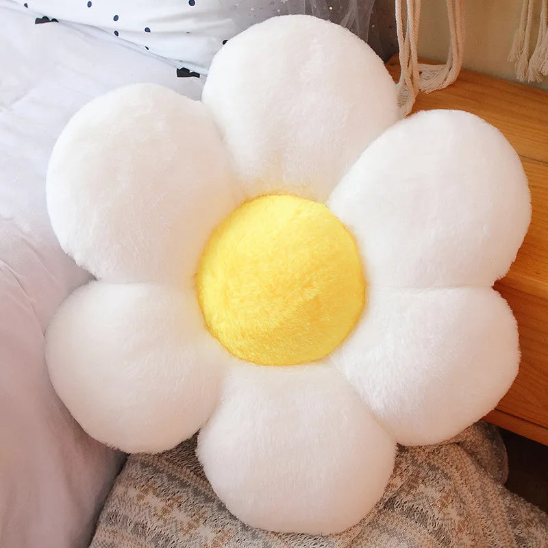 Flower-shaped Kawaii pillow with white petals and a yellow center on a soft surface.