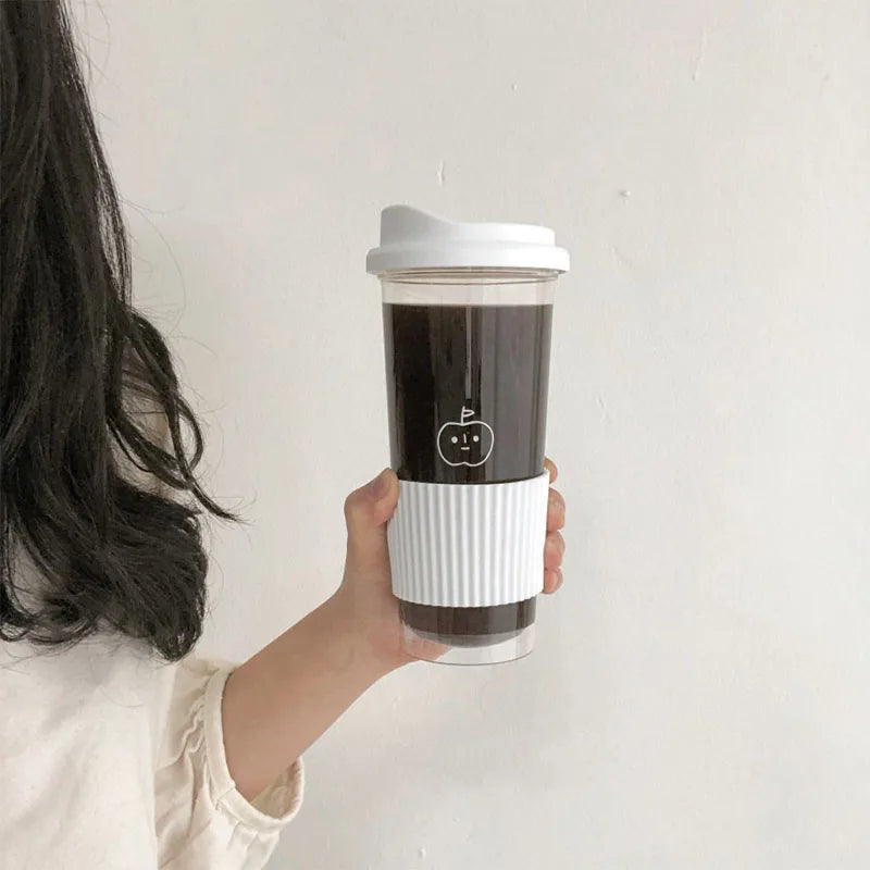 Person holding a coffee Kawaii tumbler with a white lid and black interior against a plain background