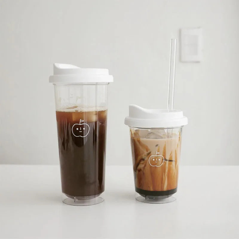 Two clear plastic Kawaii cups with lids and straws containing iced coffee on a white background