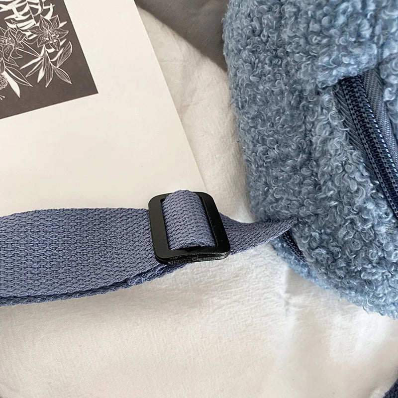 Close-up of a blue textured Kawaii-style bag with a strap and black buckle on a light background.