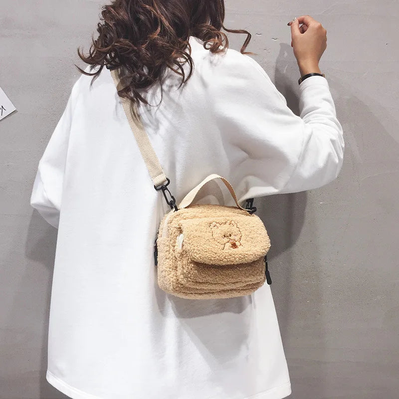 Person wearing a white coat with a beige textured Kawaii handbag on a plain background