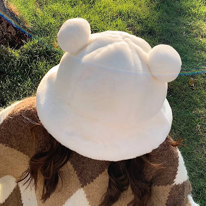 Person wearing a white Kawaii fleece hat with bear ears outdoors on grass