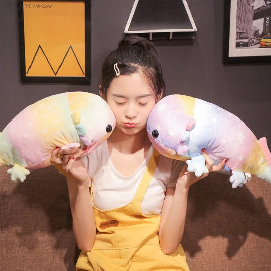 Person holding two colorful kawaii plush lizards in a room with framed pictures on the wall.