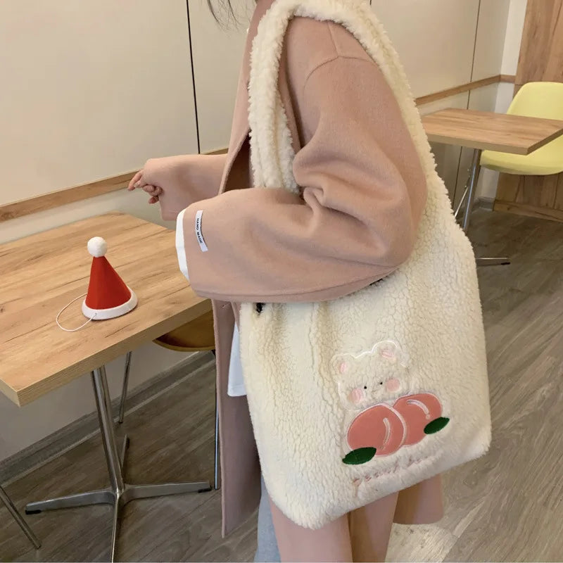 Person holding a fluffy kawaii white bag with a cartoon design, standing indoors.