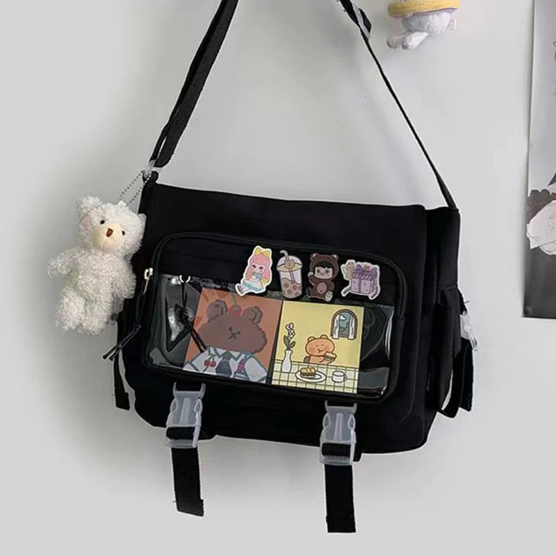 Black bag with transparent pocket displaying Kawaii cartoon bear illustrations, hanging on a white wall.