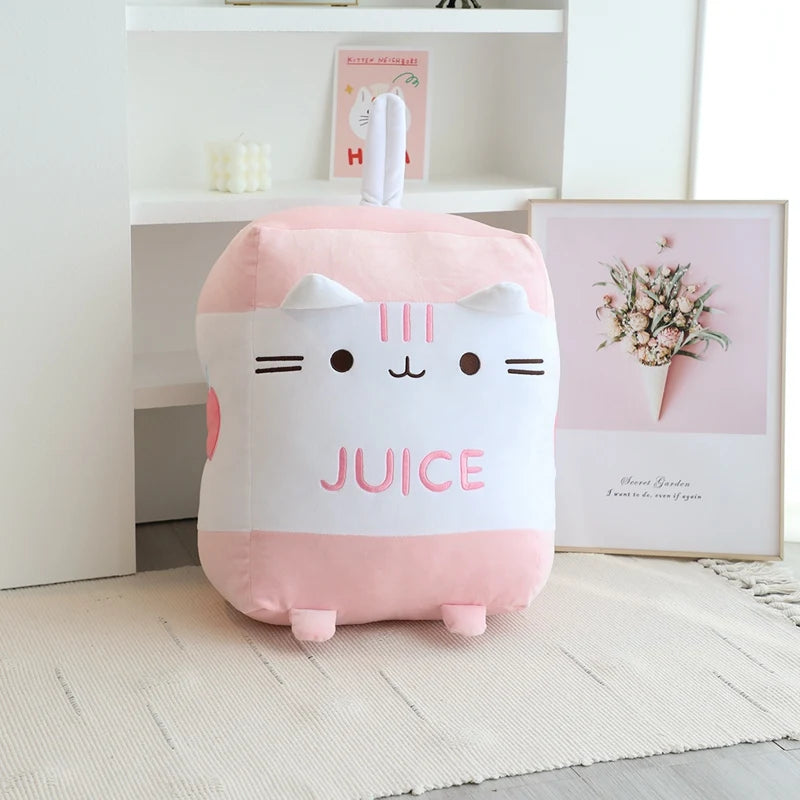 Pink kawaii plush toy with a face design and 'Juice' text on a light wooden floor.