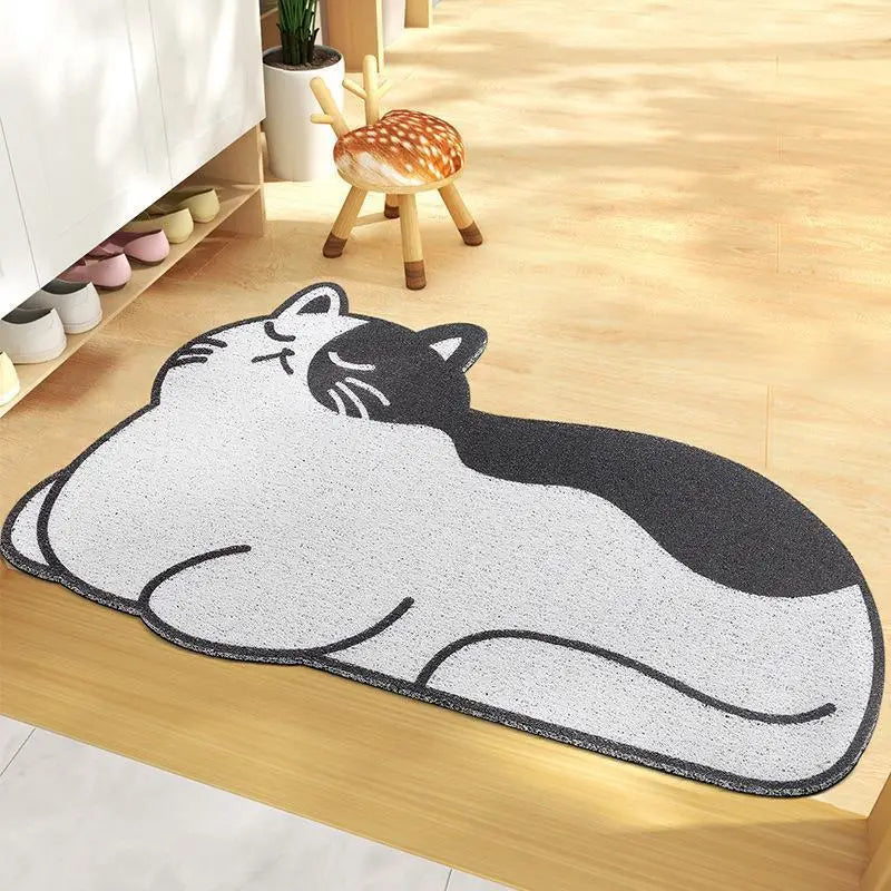 Kawaii cat-shaped doormat on a wooden floor with a small stool and shoes in the background.