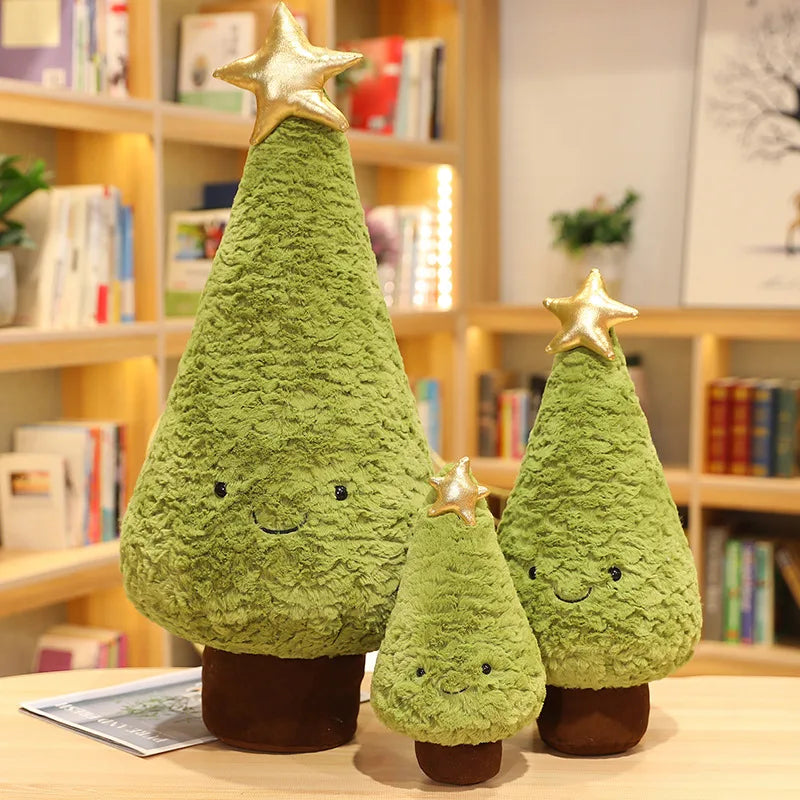 Set of three green kawaii plush Christmas trees with star toppers on a wooden surface.