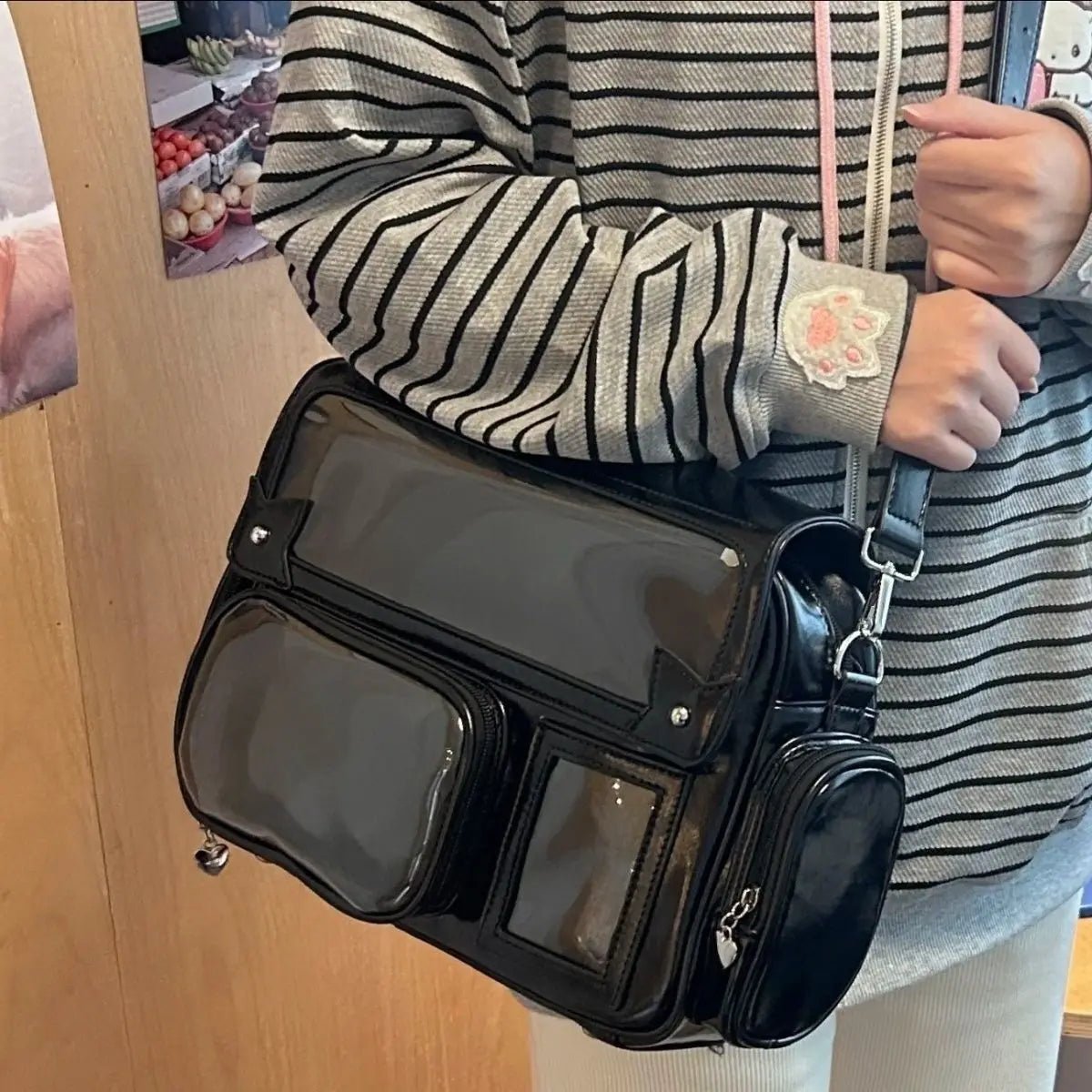 Person holding a black Kawaii handbag with transparent panels