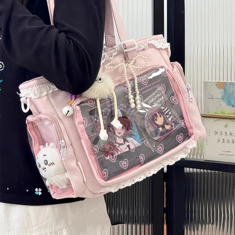 Pink Kawaii handbag with cartoon characters and lace details held by a person.