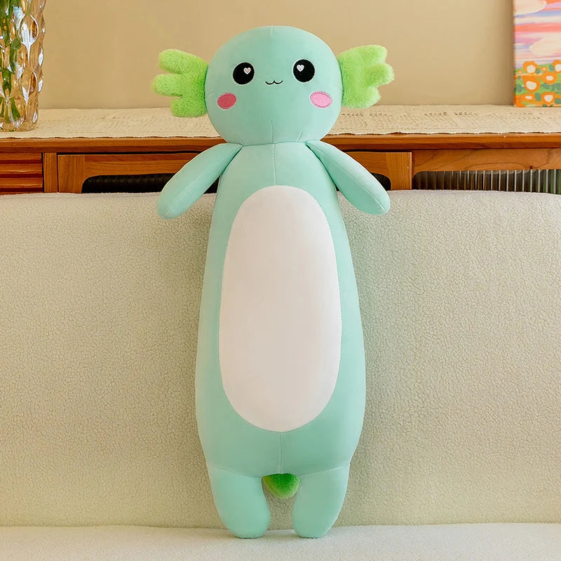 Kawaii plush toy resembling a cute creature with green hair and a white belly on a beige couch.