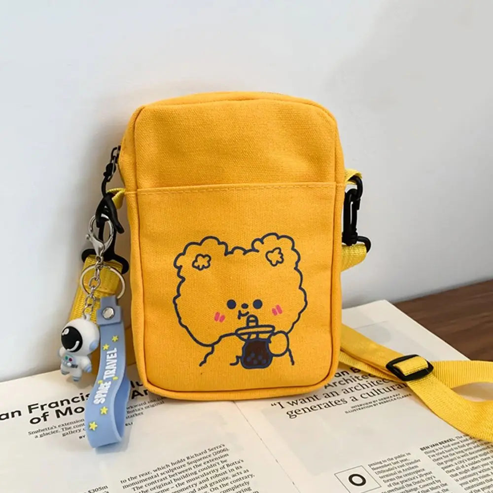 Yellow bag with a Kawaii cartoon character and keychain on an open book