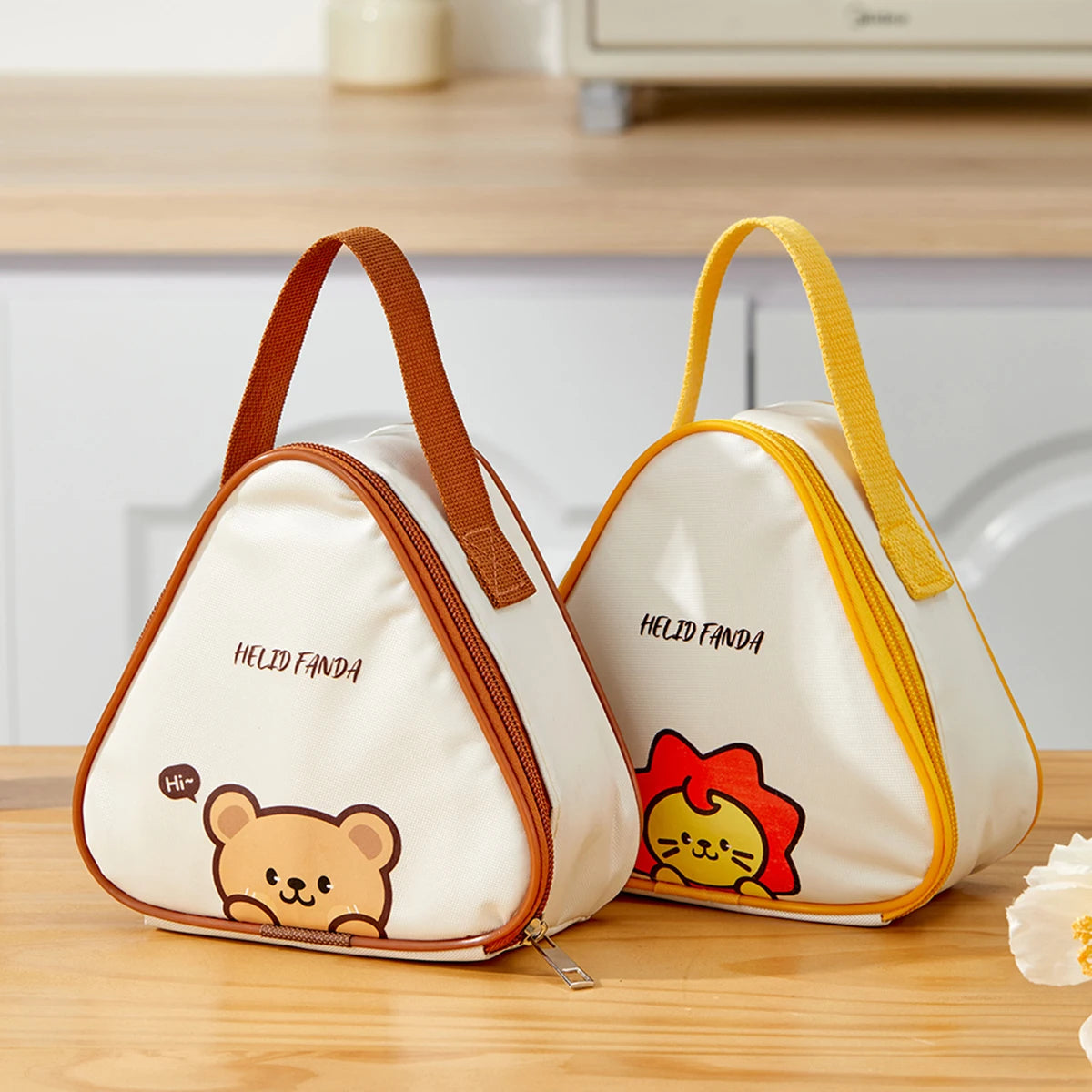 Two triangular bags with kawaii cartoon designs on a wooden surface