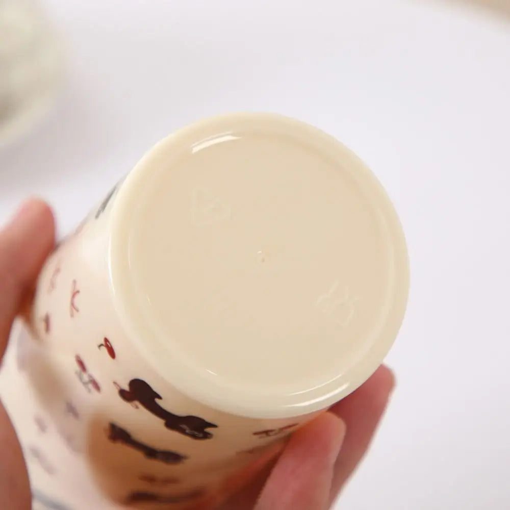 Hand holding a white container with Kawaii cat illustrations on a white background