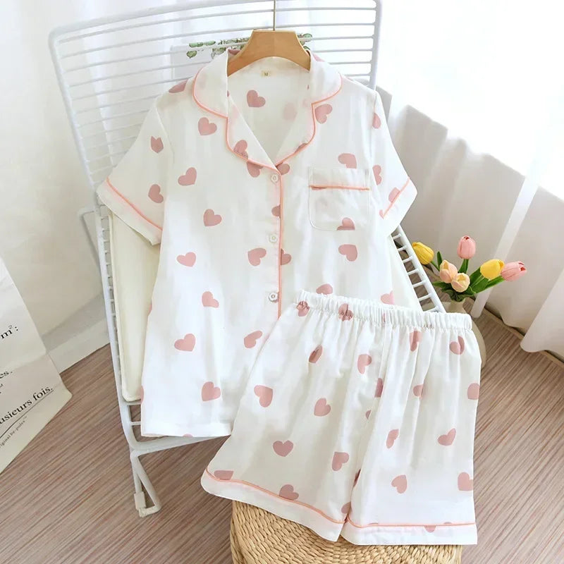 White pajama set with pink kawaii heart patterns on a chair.