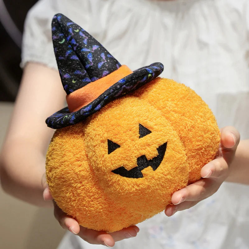 Plush kawaii toy shaped like a pumpkin with a witch hat held by a person.
