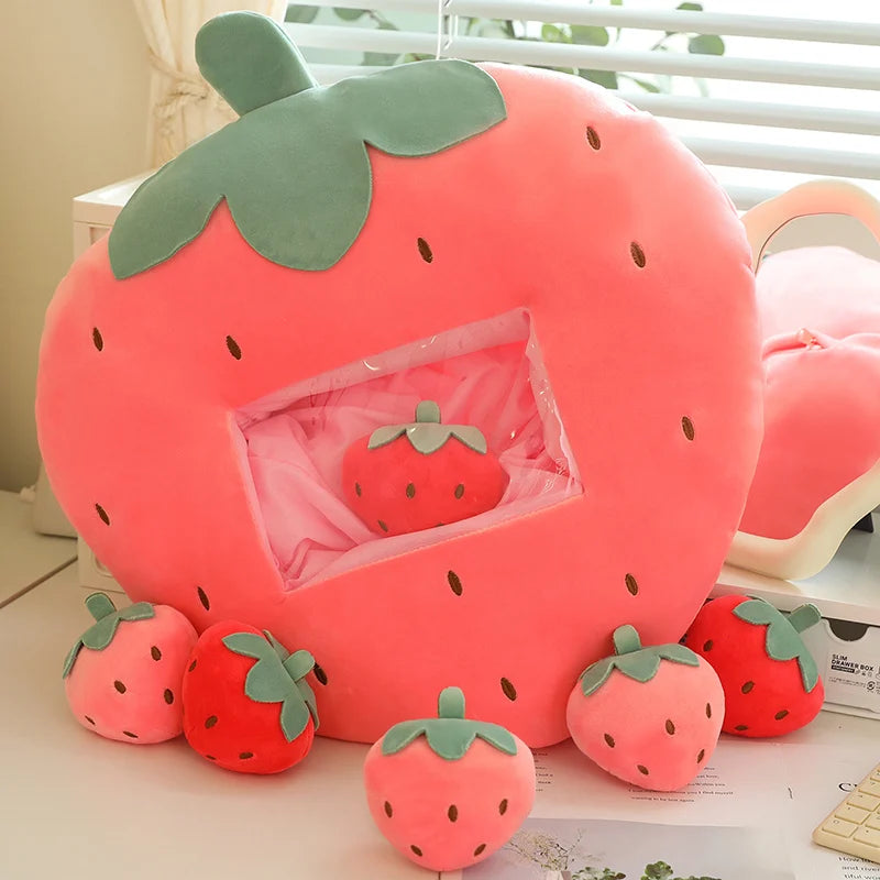 Large kawaii strawberry-shaped plush toy with smaller strawberry decorations on a surface.