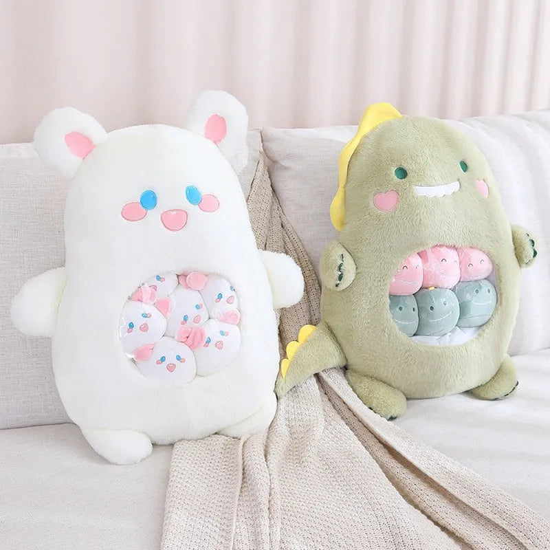 Two kawaii plush toys, one white and one green with pink accents, sitting on a couch.