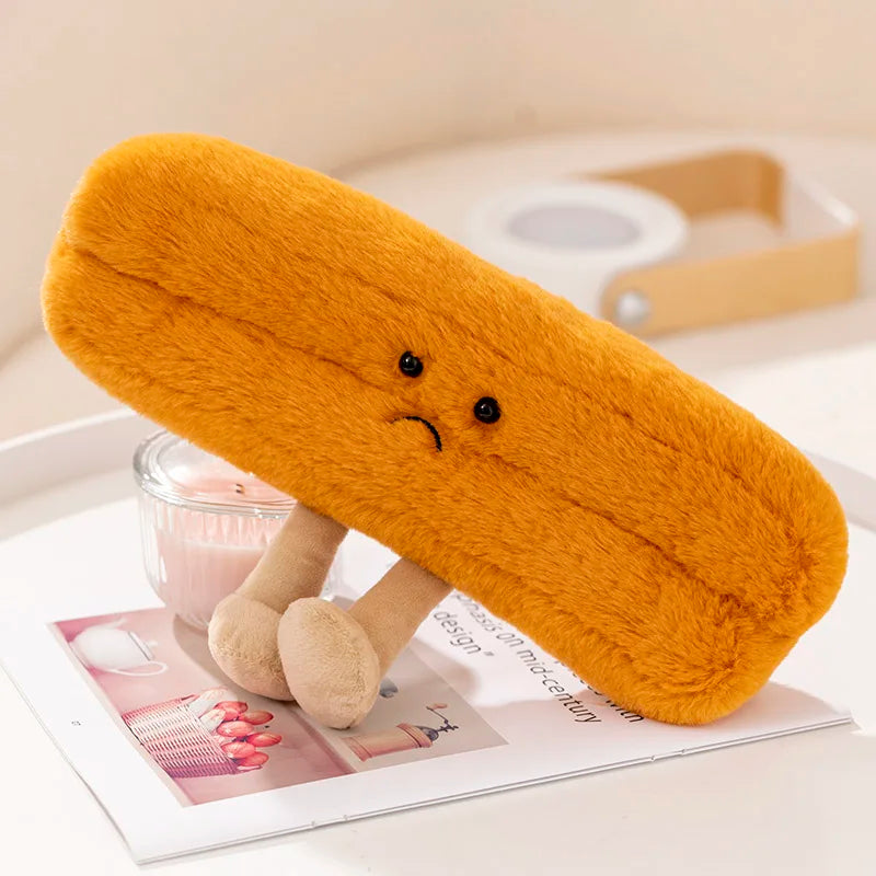 Plush kawaii toy resembling a mustard-colored bread roll with a sad face on a magazine