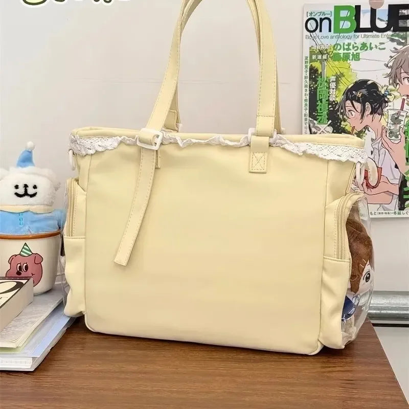 Beige handbag with lace trim on a wooden surface, with a magazine and small Kawaii plush toy in the background.