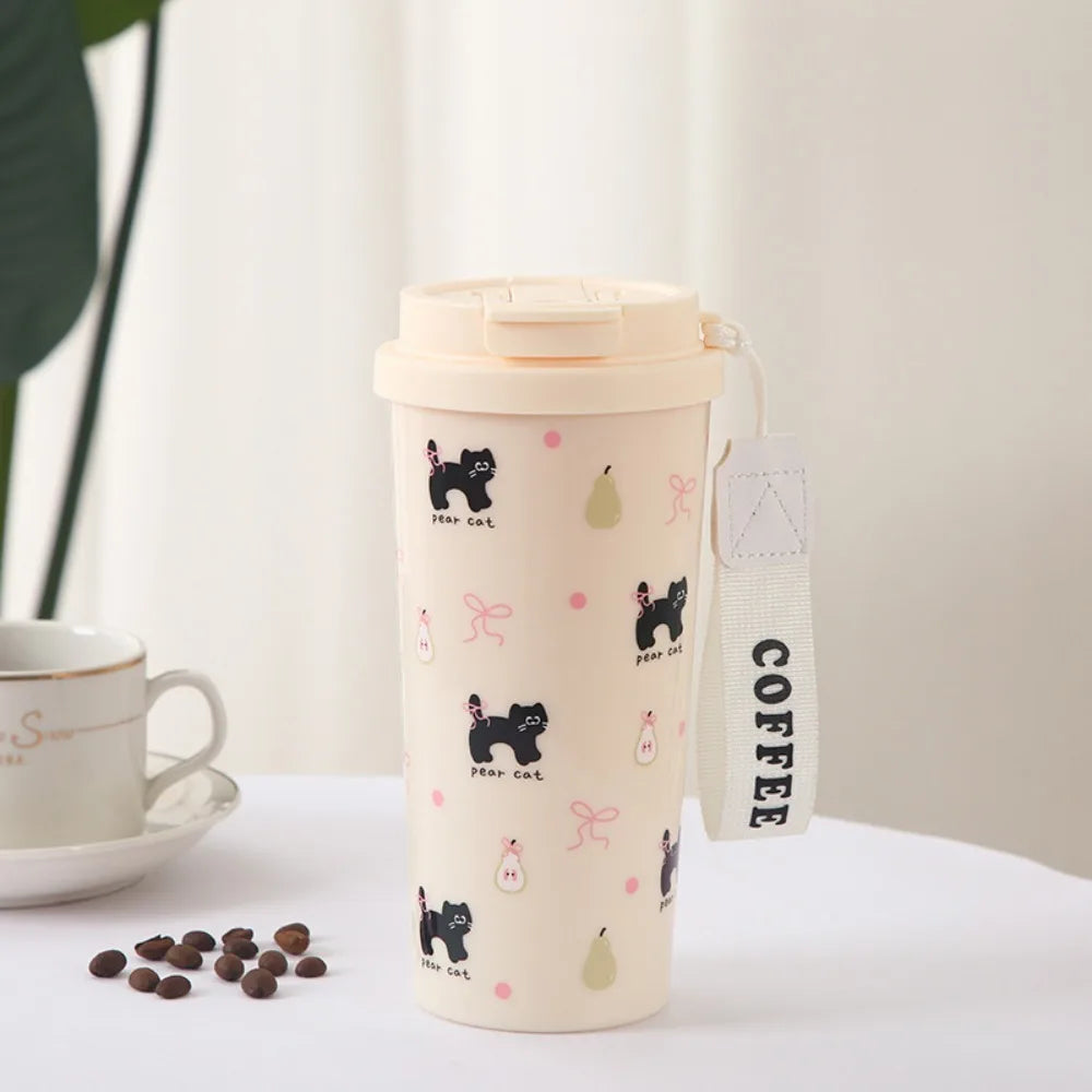 Coffee tumbler with Kawaii designs and 'COFFEE' tag next to a cup and saucer on a light surface.