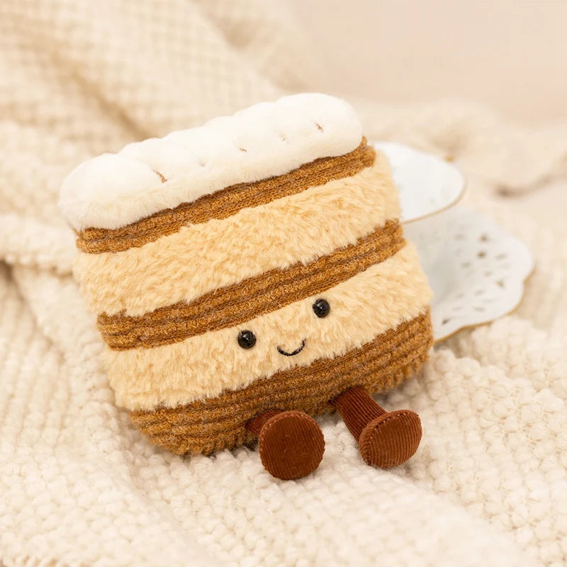 Plush kawaii toy resembling a layered dessert with a smiling face on a soft beige background