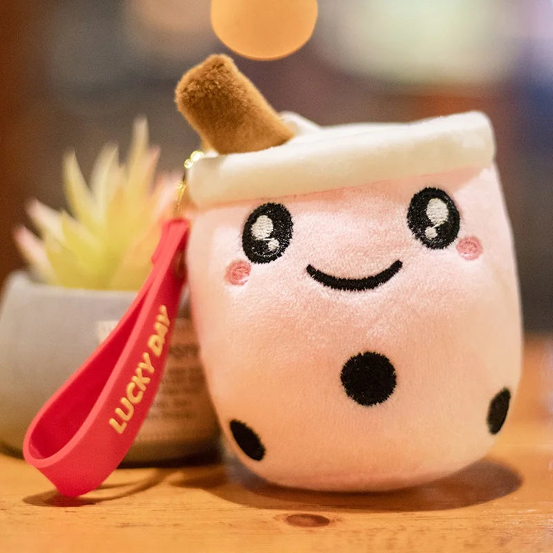 Kawaii plush toy with a face and red strap labeled 'lucky', on a wooden surface with a blurred background.
