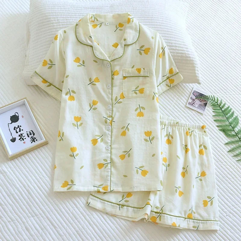 Floral kawaii pajama set on a white bed with a framed picture and plant leaf.