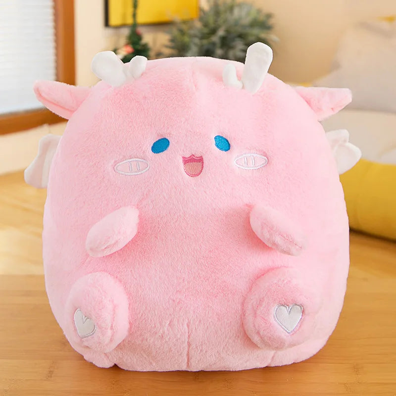 Pink kawaii plush toy with animal ears and a smiling face on a wooden surface.
