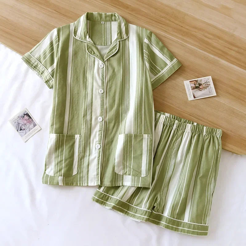 Green and white kawaii striped pajama set on a wooden surface with photos in the background.