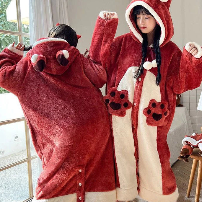 Two people wearing red and white kawaii animal-themed onesies in a room with a window.