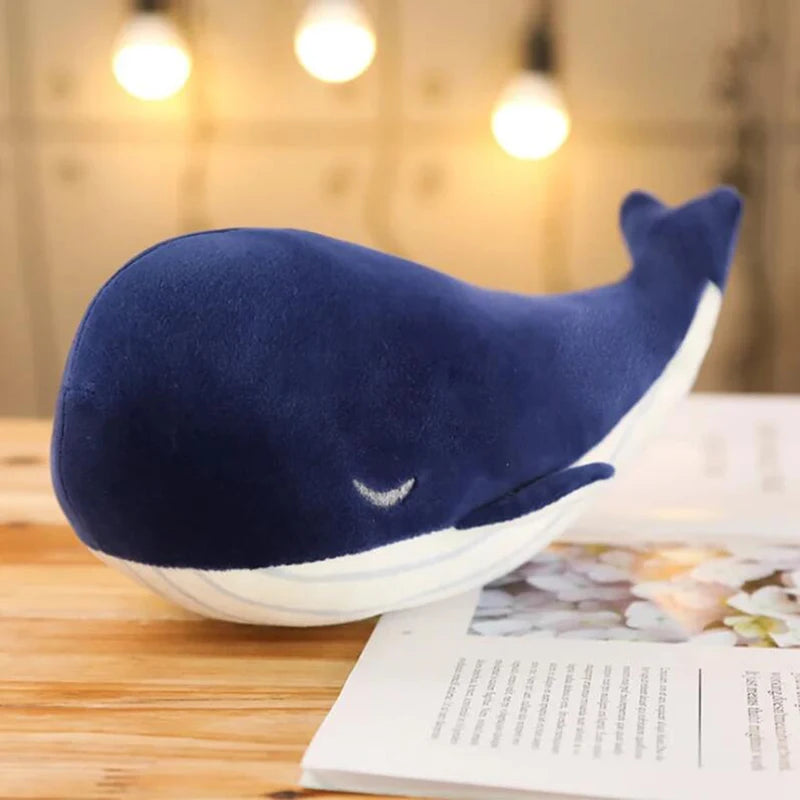 Blue plush whale kawaii toy on a wooden surface with a blurred background