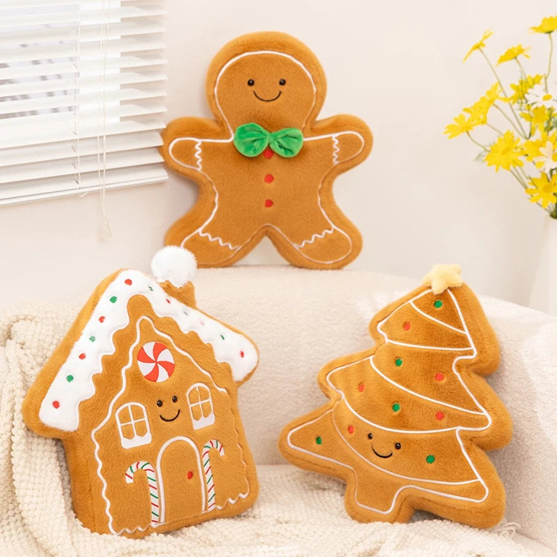 Three gingerbread-themed kawaii plush toys shaped like a man, house, and tree on a white surface.