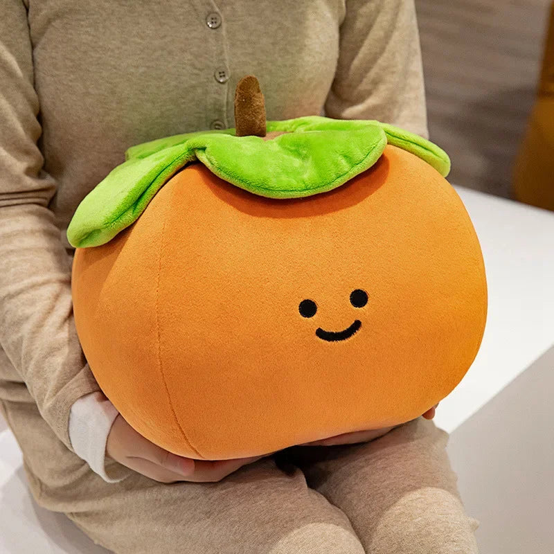 Person holding a kawaii plush peach with a smiley face design