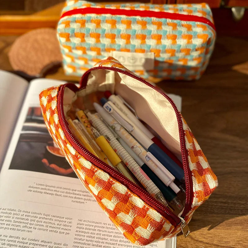 Checkered kawaii pencil case with stationery items on a magazine