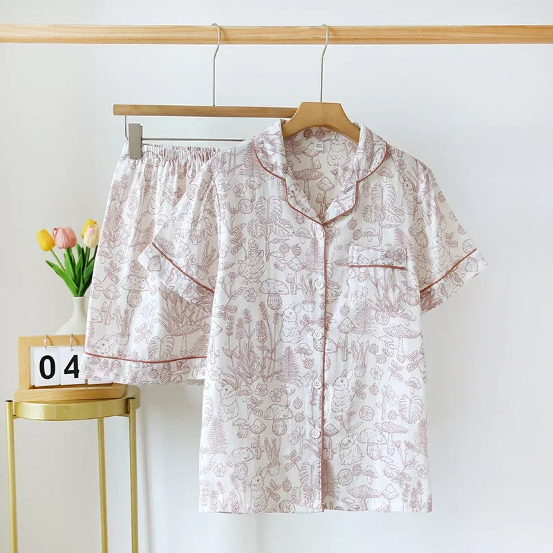 Floral kawaii pajama set hanging on a wooden hanger against a white wall with a small table and tulips in the background.
