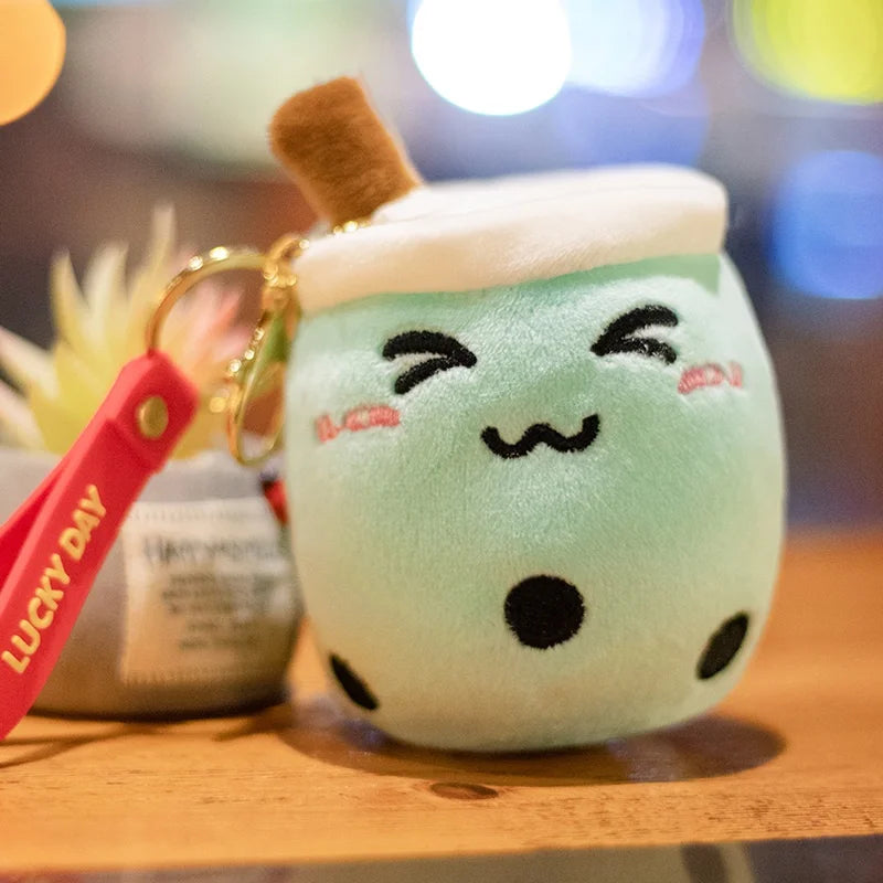 Plush toy resembling a kawaii cartoon character with a face on a wooden surface, featuring a 'Lucky Day' keychain.