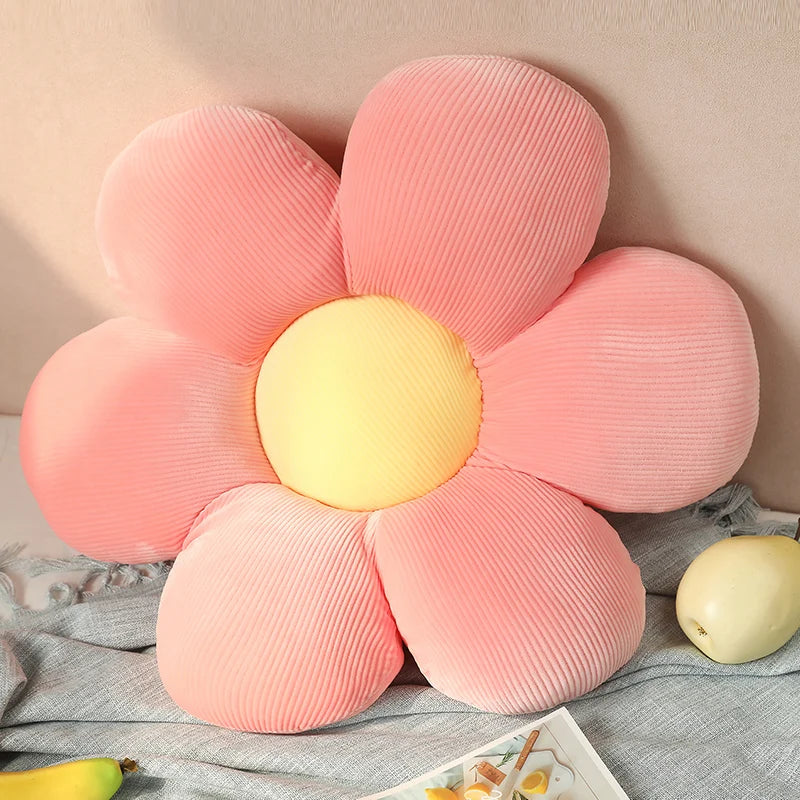 Pink Kawaii flower-shaped pillow with a yellow center on a soft surface.
