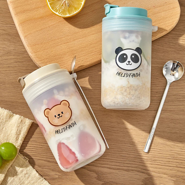 Two Kawaii cartoon-themed cups on a wooden surface with text about homemade breakfast and balanced nutrition.