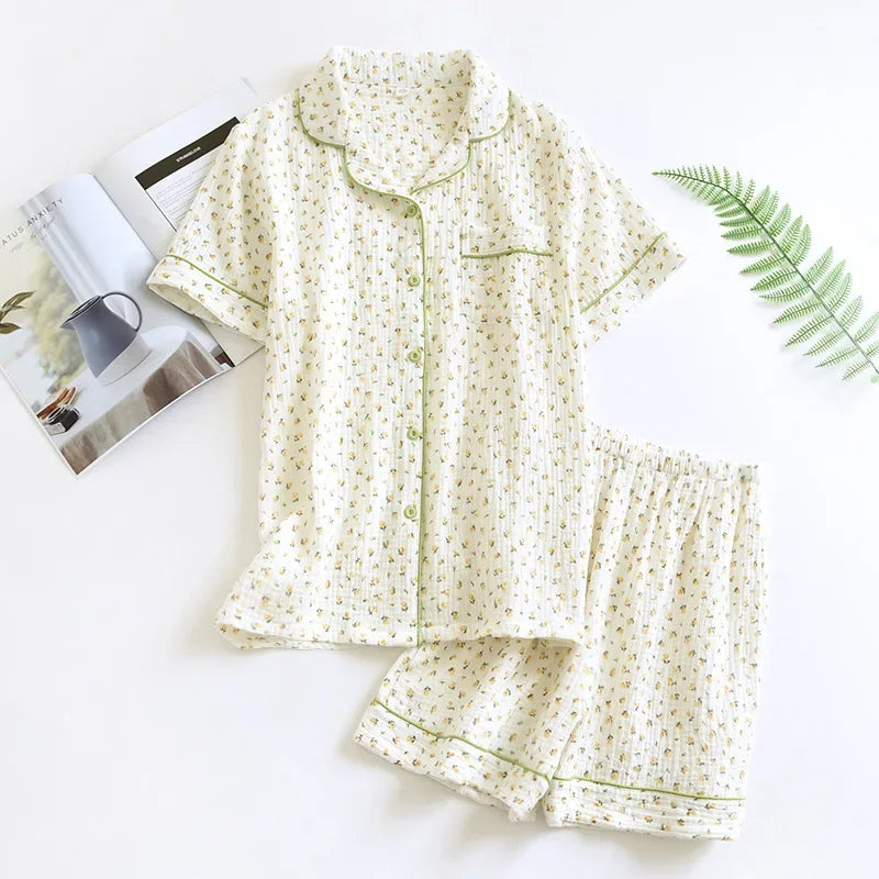 Floral kawaii pajama set on a white surface with a magazine and fern leaf.