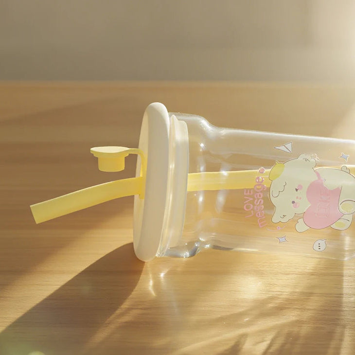 Clear water bottle with a straw and Kawaii cartoon character on a wooden surface