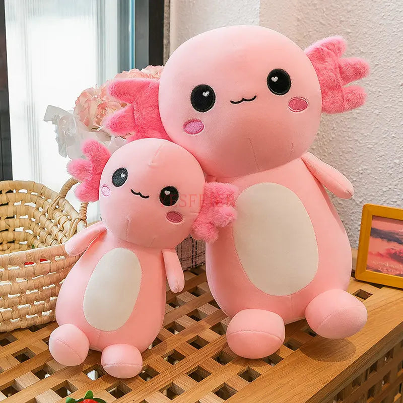 Two pink kawaii plush toys resembling axolotls on a wooden surface.