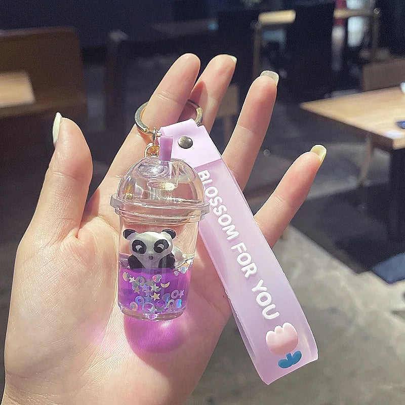 Hand holding a small transparent container with a kawaii panda design and a pink ribbon with text.