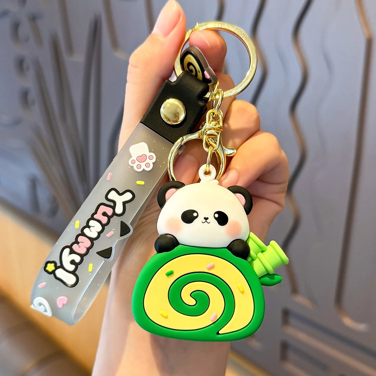 Keychain with kawaii panda design held by a hand against a neutral background
