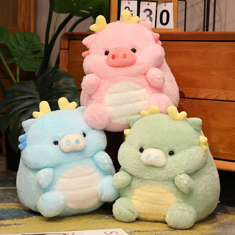 Three colorful kawaii plush toys resembling pigs on a wooden surface with a plant in the background.