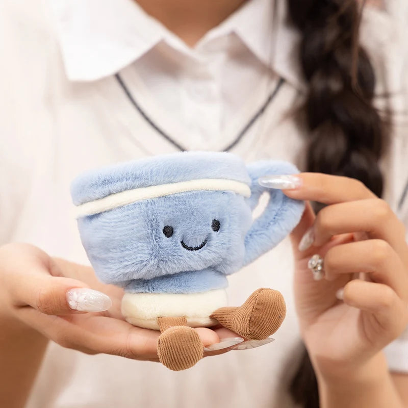 Person holding a small kawaii plush toy resembling a slice of cake with a face.