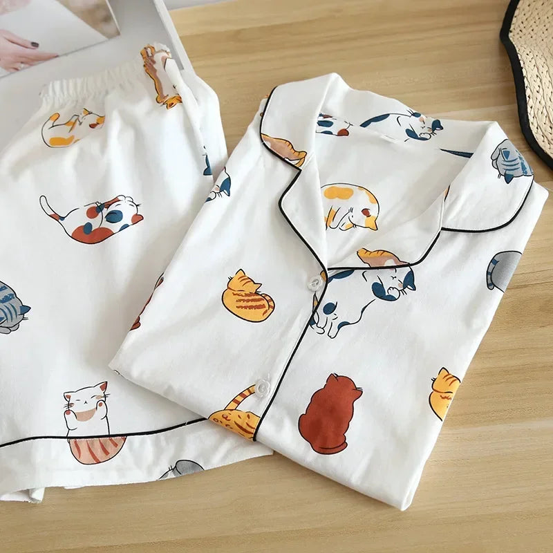 White pajama set with kawaii cat pattern on a wooden surface